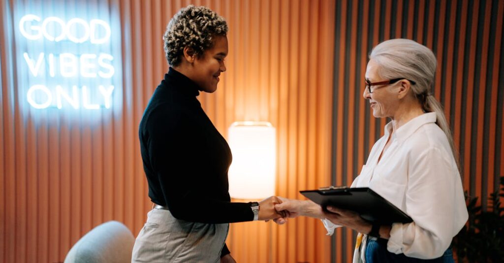 two women shaking hands during an interview
