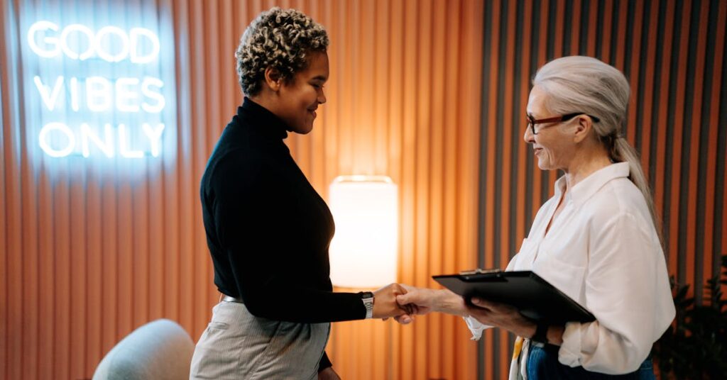 two women shaking hands during an interview