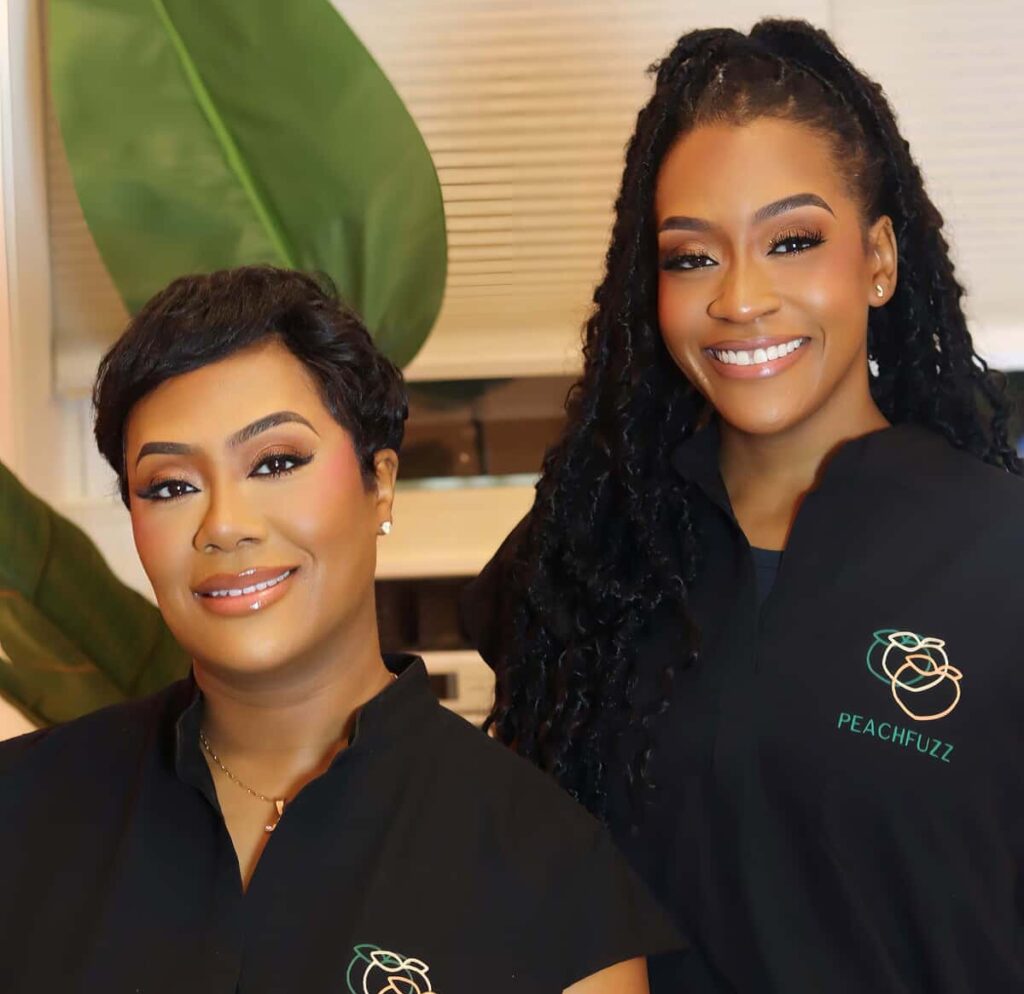 Keisha Wagner-Gaymon posing with her sister, founder and COO of Peach Fuzz Skin Studio Kristin Wagner