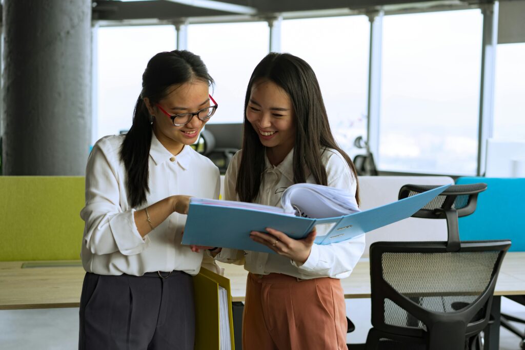 Women at work looking at binder